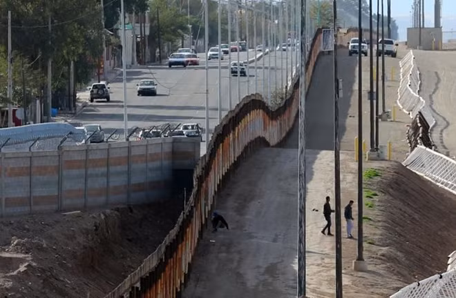 3 người đàn ông Ấn Độ vượt qua hàng rào biên giới tại Calexico, California. Ảnh Reuters
