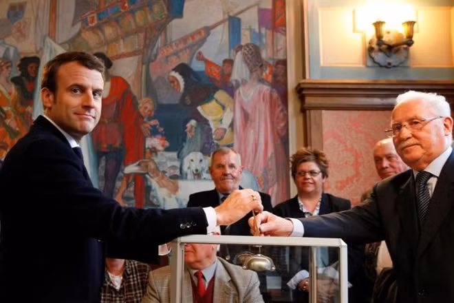 Ông Macron đi bỏ phiếu. Ảnh Reuters