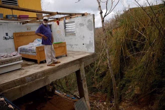 Trong ảnh là ông Roberto Morales Santos, 70 tuổi, một cư dân của khu vực Barranquitas, bên ngoài thành phố San Juan, Puerto Rico, đang đứng trên căn nhà bị thiệt hại nặng sau cơn bão Maria. Đã hơn ba tuần kể từ khi cơn bão này đổ bộ vào vùng Caribbean và để lại những thiệt hại nghiêm trọng. Người đứng đầu Puerto Rico, Ricardo Rossello miêu tả bão Maria là: “Cơn bão kinh hoàng nhất thế kỉ”.