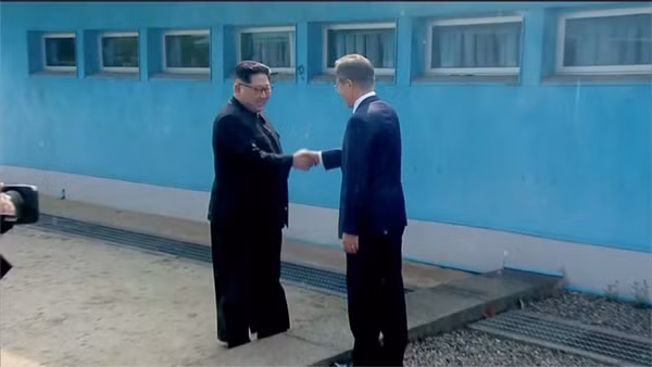 Lãnh đạo hai miền Triều Tiên bắt tay nhau trước thềm cuộc gặp ngày 27-4. Ảnh Reuters