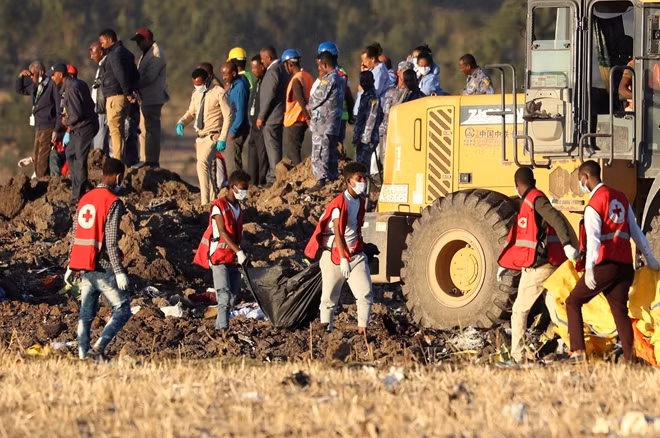 Nhân viên cứu hộ tìm kiếm các thi thể nạn nhân trong vụ rơi máy bay ở Ethiopia. Ảnh Reuters.