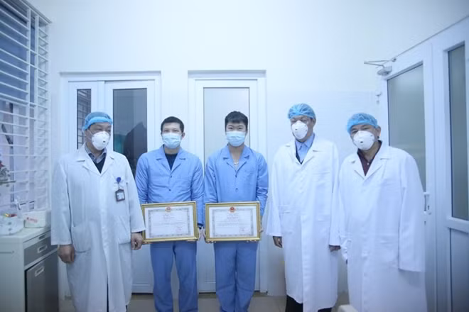 Thứ trưởng Bộ Y tế Đỗ Xuân Tuyên trao Bằng khen cho bác sĩ và điều dưỡng của BV Bệnh Nhiệt đới Trung ương tại khu vực cách ly (Ảnh: Tuấn Dũng)