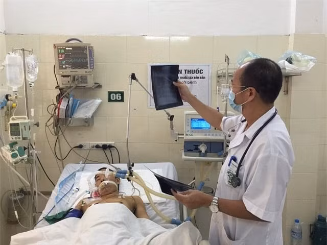 PGS.TS Đỗ Duy Cường đang thăm khám cho bệnh nhân điều trị tại Trung tâm Bệnh Nhiệt đới (Ảnh: Mai Thanh)