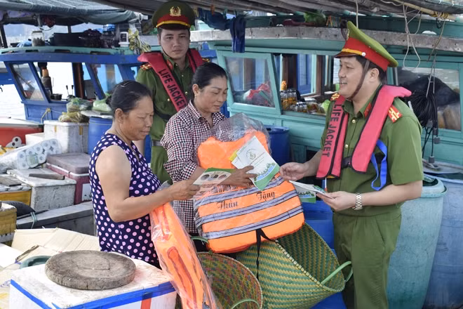 Lãnh đạo và đoàn viên Phòng Cảnh sát phòng chống tội phạm về môi trường phát tờ rơi, tặng áo phao cho ngư dân