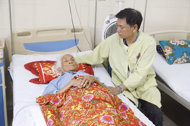 Cụ T. sau mổ đang được con trai chăm sóc