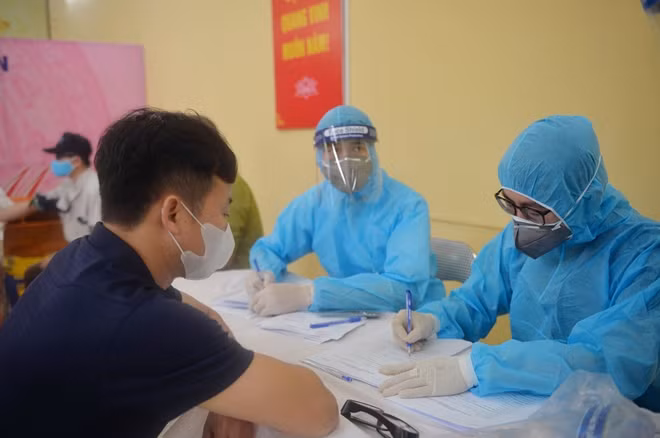 Lấy mẫu xét nghiệm nhanh COVID-19 tại chợ đầu mối Long Biên (Ảnh: N.Thắng - P.Sơn)