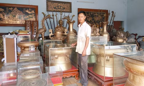 Nghệ nhân Dương bên những chiếc trống đồng.
