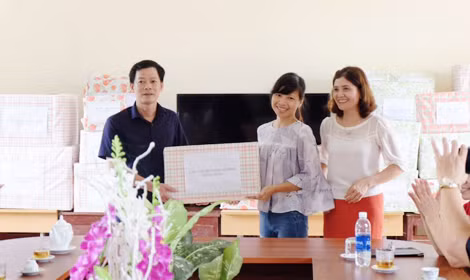 Cô giáo Giáng Hương (ở giữa) trao quà ở Trường cấp 1, 2 xã Lạc Sỹ, huyện Yên Thủy, Hòa Bình.