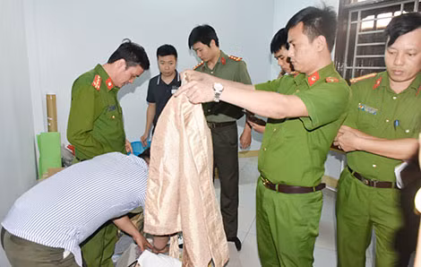 Cán bộ công an khám xét, thu giữ nhiều tang vật liên quan đến việc truyền đạo trái pháp luật.
