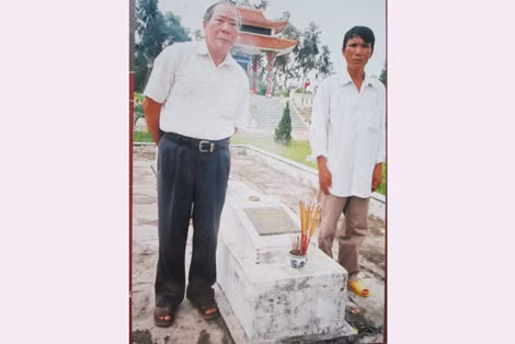 Nhà thơ, thầy giáo Nguyễn Hữu Phi (bên trái) cùng anh Nguyễn Văn Thùy bên mộ liệt sĩ Nguyễn Xuân Cang tại nghĩa trang liệt sĩ xã Cự Nẫm.