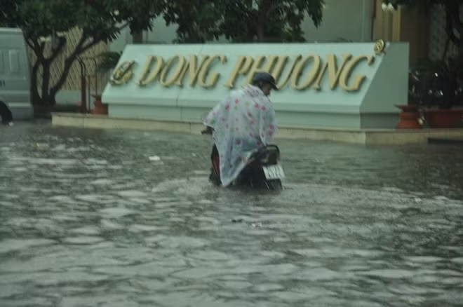 Người phụ nữ đau khổ vì xe chết máy giữa dòng nước đen ngòm, hôi thối.