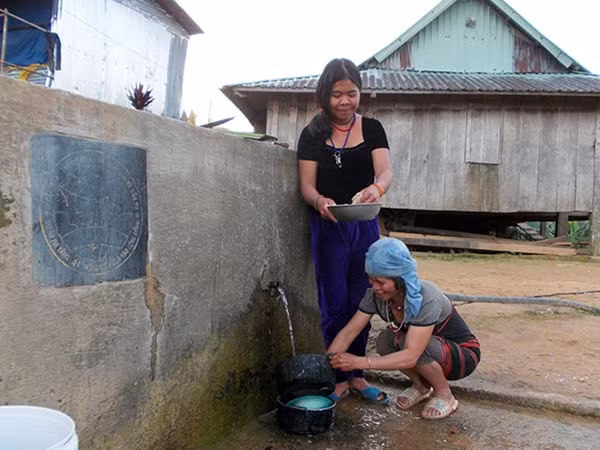Người dân Atu 1 bên hồ chứa nước tự chảy duy nhất của thôn để chuẩn bị mâm cơm ngày Tết cổ truyền.