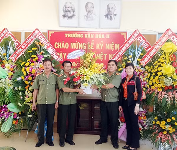 Trung tá Nguyễn Đức Vinh, Phó trưởng Cơ quan Đại diện Báo CAND tại TP Hồ Chí Minh tặng lẵng hoa chúc mừng thầy trò Trường Văn hóa II.