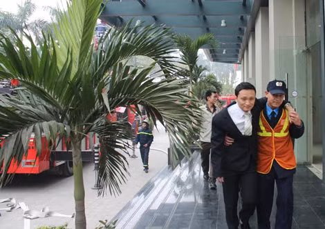 Lực lượng chữa cháy sở tại dìu nạn nhân ra ngoài an toàn.