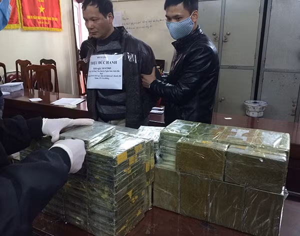 Đối tượng Triệu Đức Hanh cùng 156 bánh heroin tang vật tại cơ quan Công an.