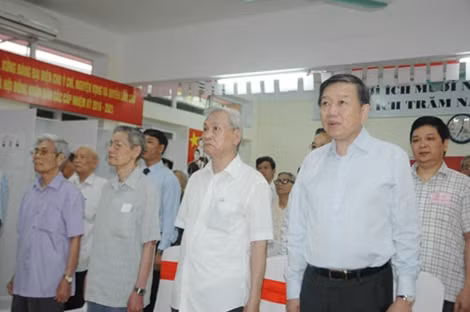 Bộ trưởng Tô Lâm và các cử tri thực hiện nghi thức chào cờ. Ảnh: Tâm Phạm