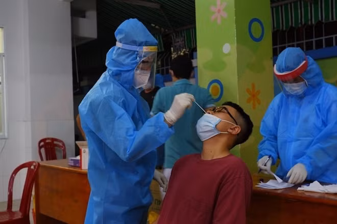 Ngành y tế lấy mẫu xét nghiệm tầm soát cho người dân tại khu vực có ca nghi nhiễm COVID-19.