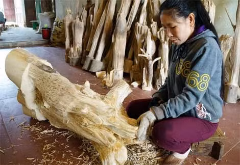 Công nhân đang xử lý những gốc trầm hương và đồ nghề để tạo trầm.