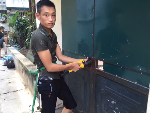Đối tượng Công đang thực nghiệm lại hiện trường dùng kìm thủy lực cắt khóa cổng và khóa chữ U chống trộm lấy trộm 3 lần với gần chục chiếc xe máy tại khu nhà trọ ở phường Xuân Đỉnh.
