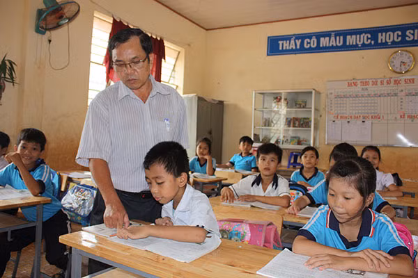 Thầy giáo Hoàng Trọng Văn - giáo viên Trường Tiểu học Lộc Thiện B, xã Lộc Thiện, huyện Lộc Ninh, tỉnh Bình Phước với các em học sinh.