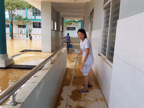 Các y bác sĩ tiến hành dọn bùn khi nước lũ vừa rút ra ngoài.