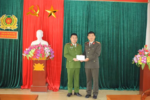 Đại tá Dương Văn Tính - Phó Giám đốc Công an tỉnh Bắc Kạn trao 10 triệu đồng cho Công an huyện Đà Bắc.