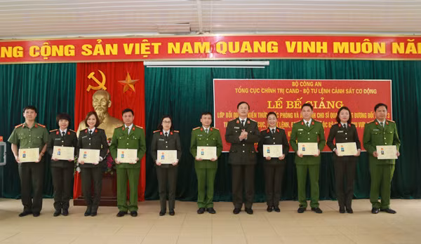 Thiếu tướng, GS.TS Bùi Minh Giám, Phó Tổng cục trưởng Tổng cục Chính trị CAND trao Giấy chứng nhận hoàn thành chương trình bồi dưỡng kiến thức quốc phòng và an ninh cho các học viên có thành tích xuất sắc.