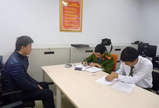 Đối tượng truy nã Chen Hai Bin (trái) khai báo tại cơ quan Công an Việt Nam.