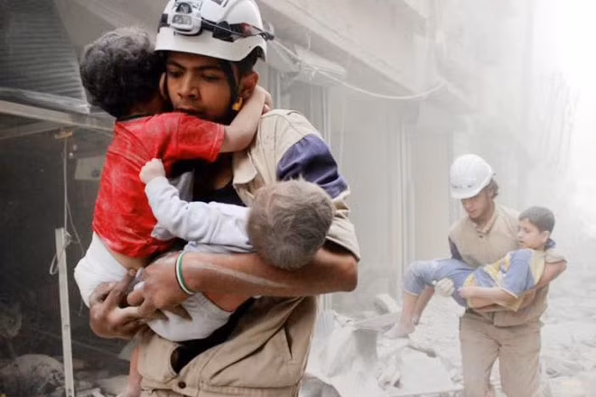 Các nhân viên cứu trợ đang khẩn trương đưa các em bé ở khu vực Al-Shaar, gần thành phố Aleppo đến nơi an toàn sau khi nơi này bị tấn công. Ảnh: Reuters.