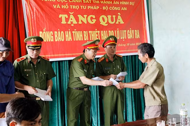 Đại tá Nguyễn Văn An, Phó giám đốc Công an tỉnh Hà Tĩnh trao quà cho người dân bị thiệt hại do lũ gây ra.