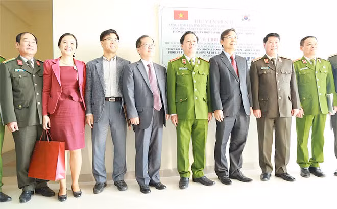 Thứ trưởng Bùi Văn Nam và các đại biểu chụp ảnh lưu niệm tại biển tên Thư viện điện tử Học viện CSND.