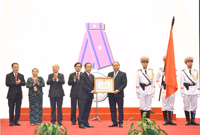Thay mặt lãnh đạo Đảng, Nhà nước, Thủ tướng Nguyễn Xuân Phúc trao Huân chương Lao động hạng Ba cho Hiệp hội DNNVV. Ảnh: VGP/Quang Hiếu