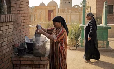 Một phụ nữ sống trong khu nghĩa trang Cairo đang làm sạch các ngôi mộ.
