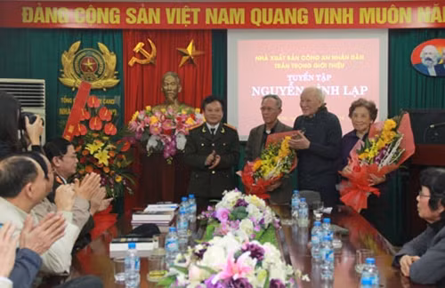Đại tá, nhà văn Nguyễn Hồng Thái tặng hoa cho thân nhân gia đình nhà văn Nguyễn Đình Lạp.