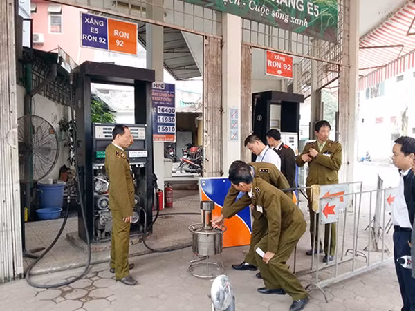 Lực lượng chức năng kiểm tra cây xăng gian lận.