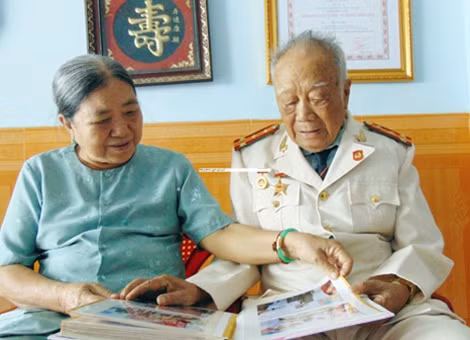 Vợ chồng Đại tá Nguyễn Hòa lật giở album ảnh xem những kỷ niệm của gia đình, đồng đội.