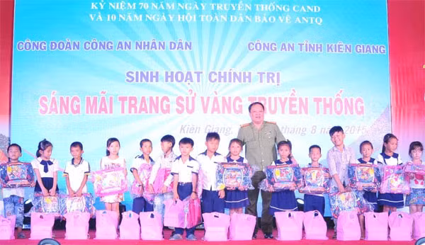 Đại tá Nguyễn Văn Pháp - Phó cục trưởng Cục Công tác Đảng và công tác Quần chúng (Tổng cục Chính trị CAND) trao quà cho các em học sinh.