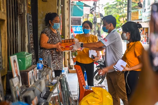 Cán bộ phường Lý Thái Tổ đem mỳ tôm và trứng tới từng nhà.