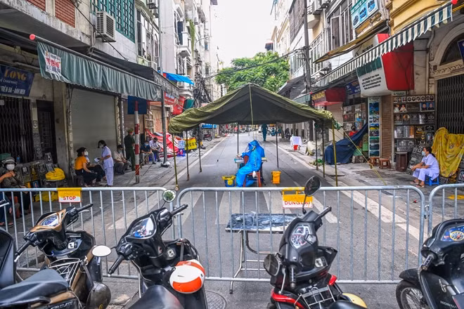 Lực lượng y tế quận Hoàn Kiếm tại lều dã chiến được dựng lên để phục vụ việc lấy mẫu xét nghiệm COVID-19 cho người dân ở phố Hàng Mắm (Hà Nội).