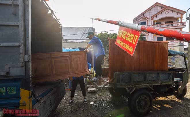 Đoàn viên thanh niên giúp đỡ người dân vận chuyển đồ ra ngoài sau khi đã được kiểm tra và phun khử trùng.