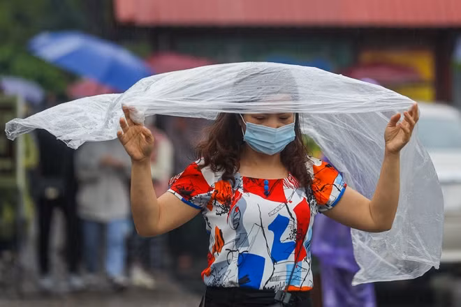 Du khách đội mưa đi lễ chùa.