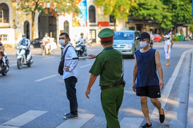 Lực lượng công an quận Hoàn Kiếm nhắc nhở người dân tập thể dục ven hồ.