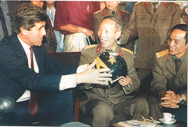 Đại tá Phạm Đức Đại (bên phải) trao cho Thượng nghị sĩ John Kerry chiếc mũ của phi công John McCain.