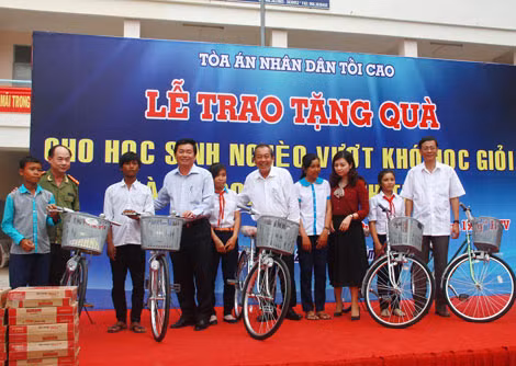 Học sinh nghèo hiếu học vui mừng khi được đồng chí Trương Hòa Bình, Bí thư Trung ương Đảng, Chánh án TAND tối cao cùng đại diện Báo Công an nhân dân và nhà tài trợ trao tặng xe đạp.
