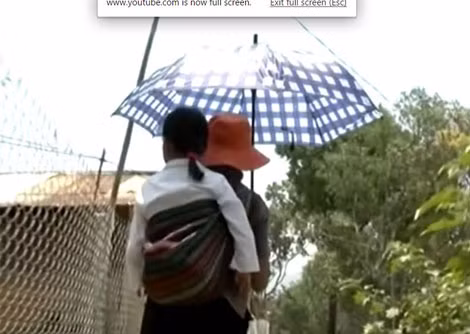 K'Niêm trên lưng mẹ đến trường.