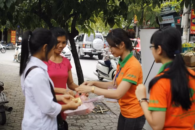 Các tình nguyện viên phục vụ cơm miễn phí cho sĩ tử, người nhà tại điểm thi trường THCS Trung Hòa, Cầu Giấy, Hà Nội.