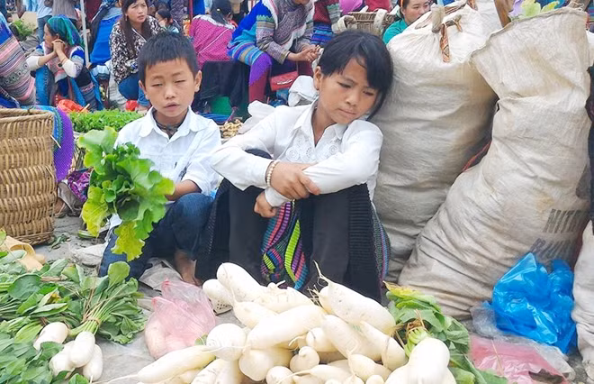 Hai chị em tranh thủ ngày nghỉ học đi bán rau.