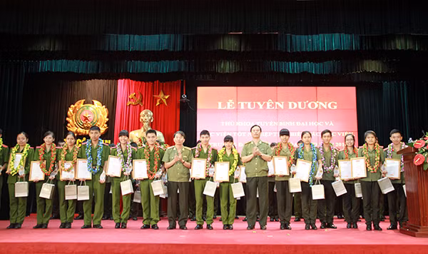 Trung tướng Trần Bá Thiều, Tổng cục trưởng Tổng cục Chính trị CAND và Thiếu tướng Bùi Minh Giám, Cục trưởng Cục Đào tạo tặng hoa các cá nhân là thủ khoa đại học và học viên tốt nghiệp tiêu biểu các trường CAND.