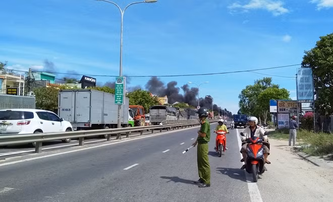 Công an thị trấn Nam Phước phân luồng điều tiết giao thông qua khu vực xảy ra đám cháy.
