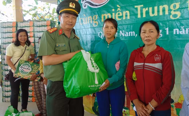 Thượng tá Nguyễn Văn Long, Trưởng Văn phòng thường trú Báo CAND tại miền Trung, tận tay trao quà cho bà con tại huyện Đại Lộc.